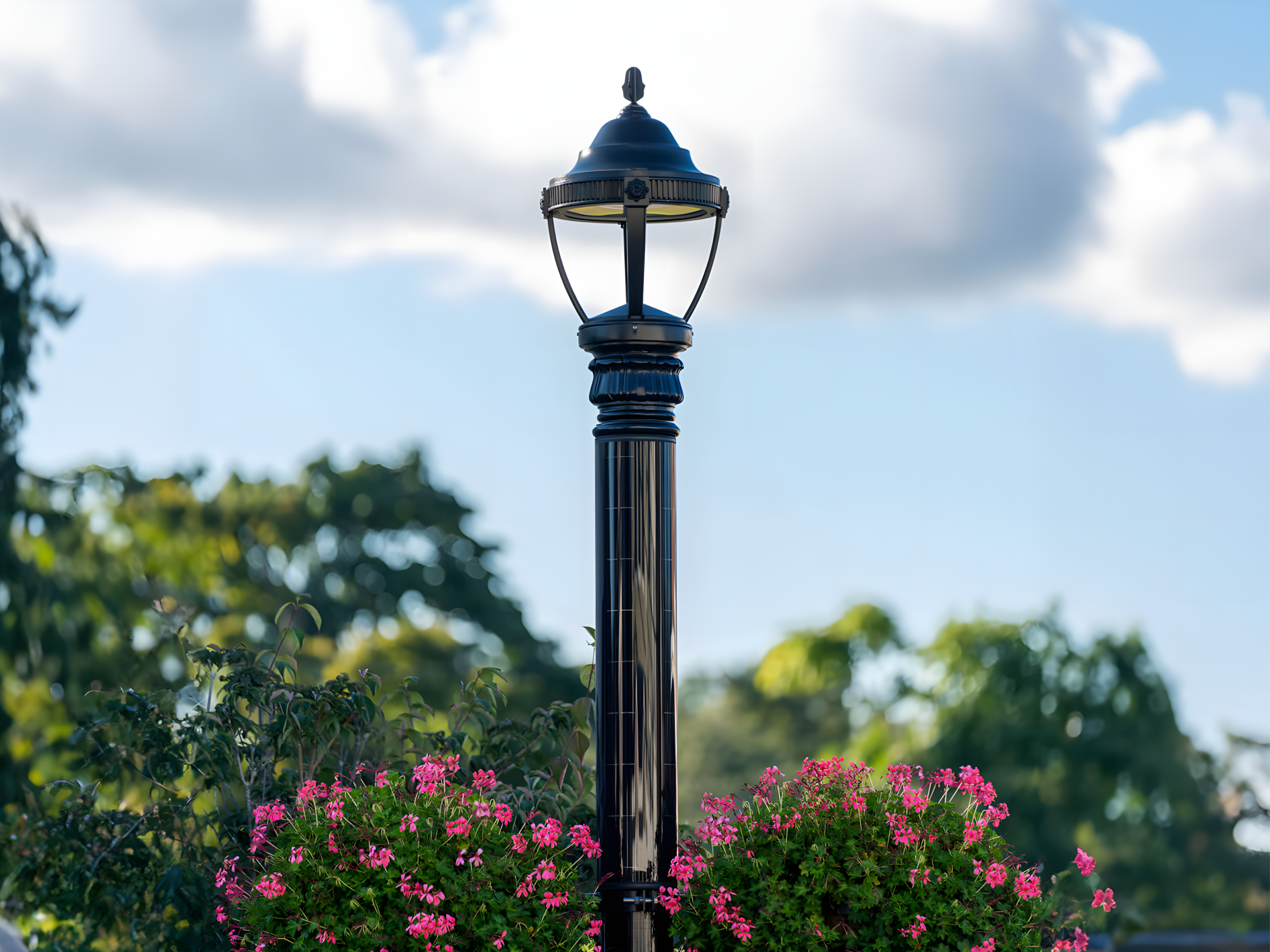 Decorative solar pole with a classic lantern-style fixture and hanging flower baskets.