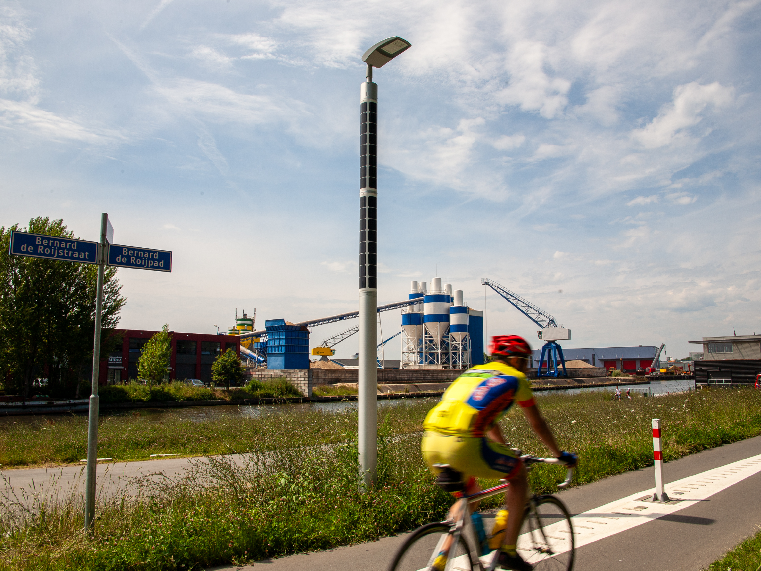 Solar-powered streetlight beside a cycling route with street signs in Amersfoort.