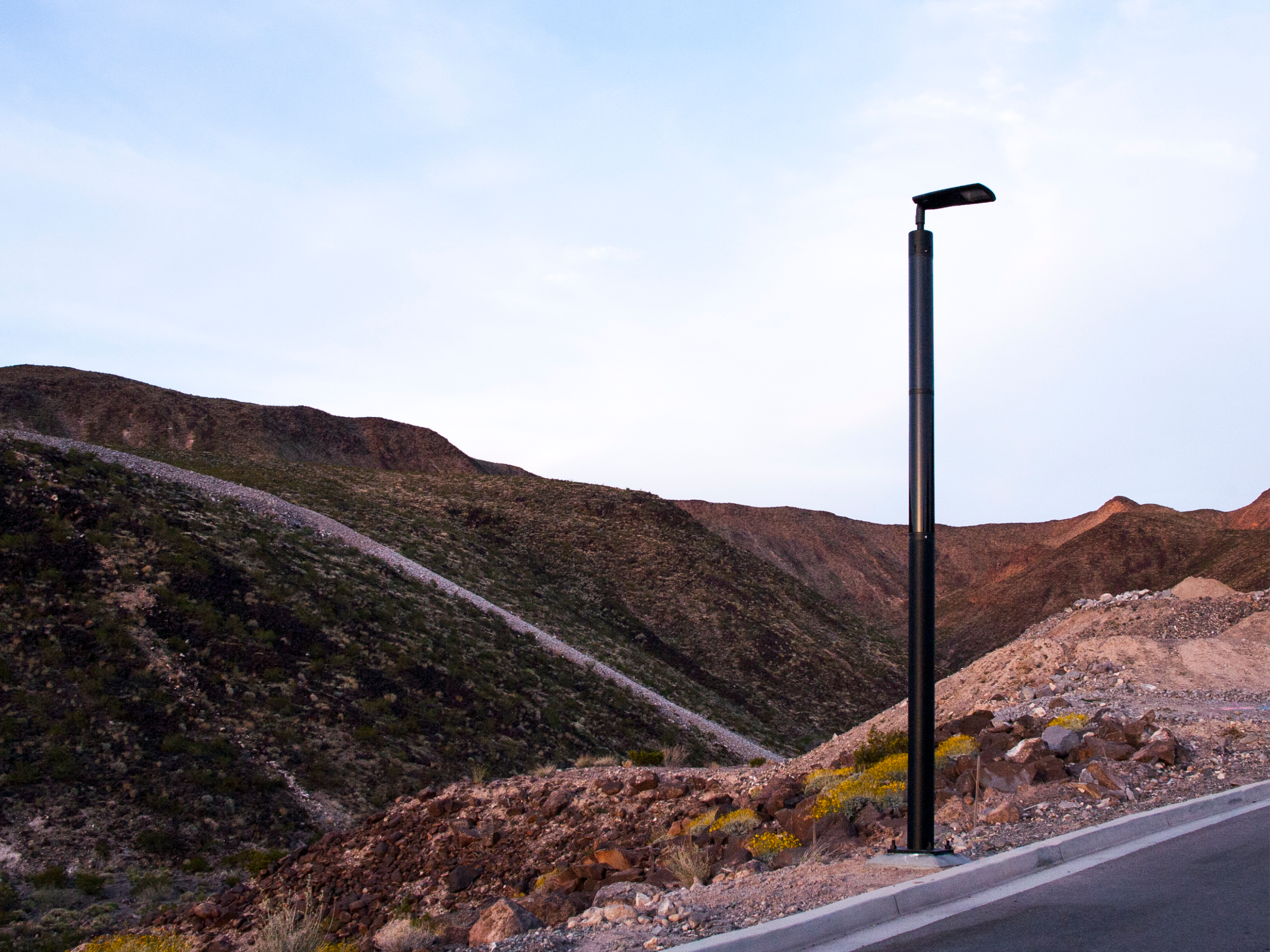 Solar-powered streetlight installed along a road in a desert landscape in Nevada.